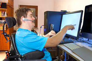 Man interacting with computer using assistive technology