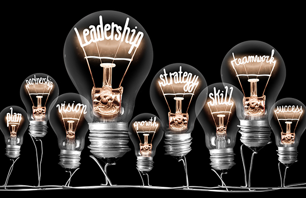 Photo of light bulbs group with shining fibers in a shape of LEADERSHIP concept related words isolated on black background