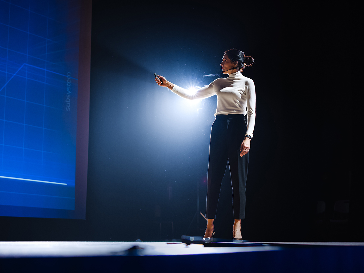 Woman giving presentation in front of large screen