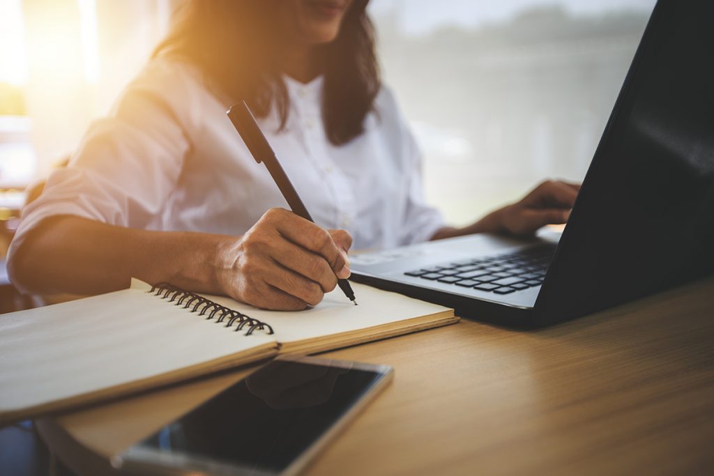 Woman Using Computer Taking Notes OLC